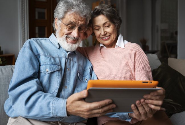 Senior couple looking at laptop illustrates blog "Is Medicare Part C the Same as Medicare Advantage?"