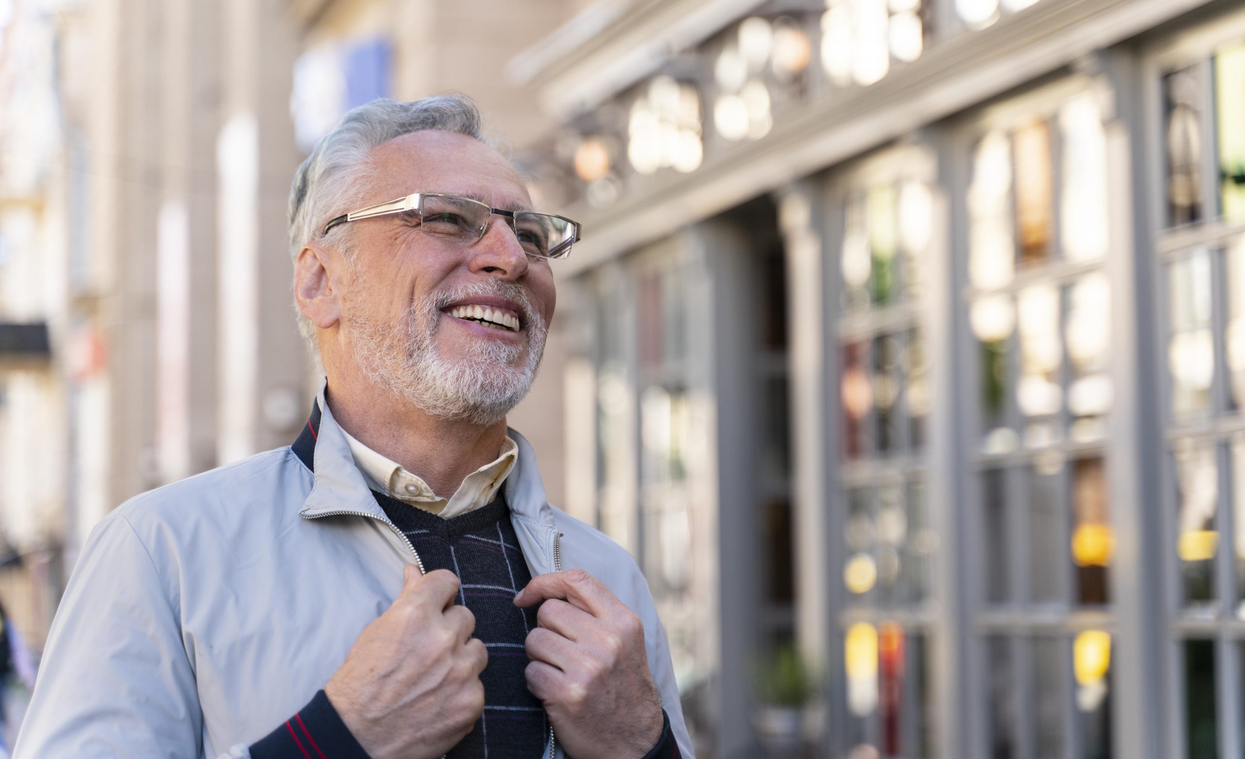 Senior man smiling as he walks down a street illustrates blog "Can I Enroll in a Medicare Advantage Plan Anytime?"