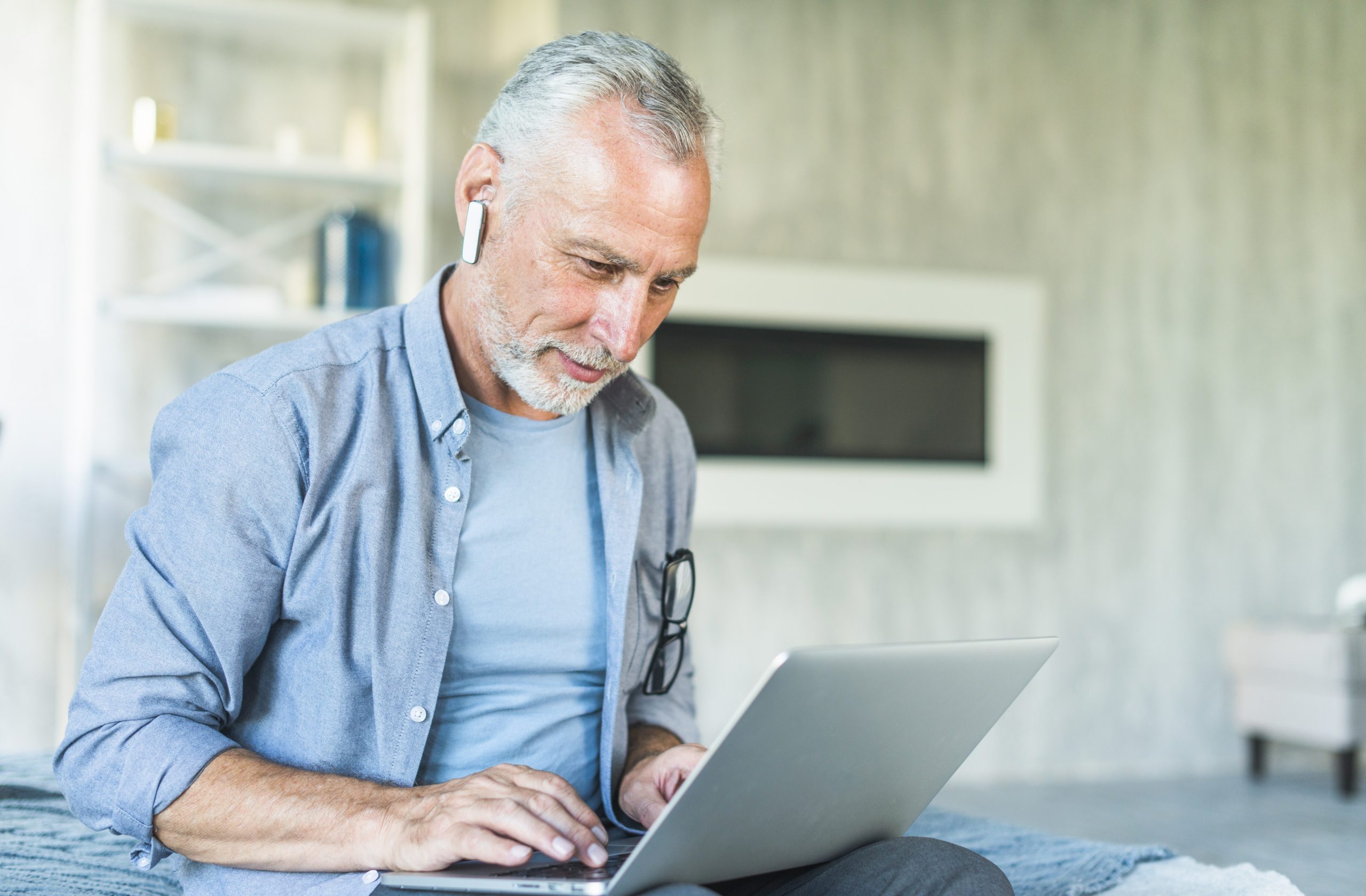 senior-man-laptop-fp Senior man looking at laptop in living room illustrates blog "Are Catheters Covered by Medicare Advantage Plans?"