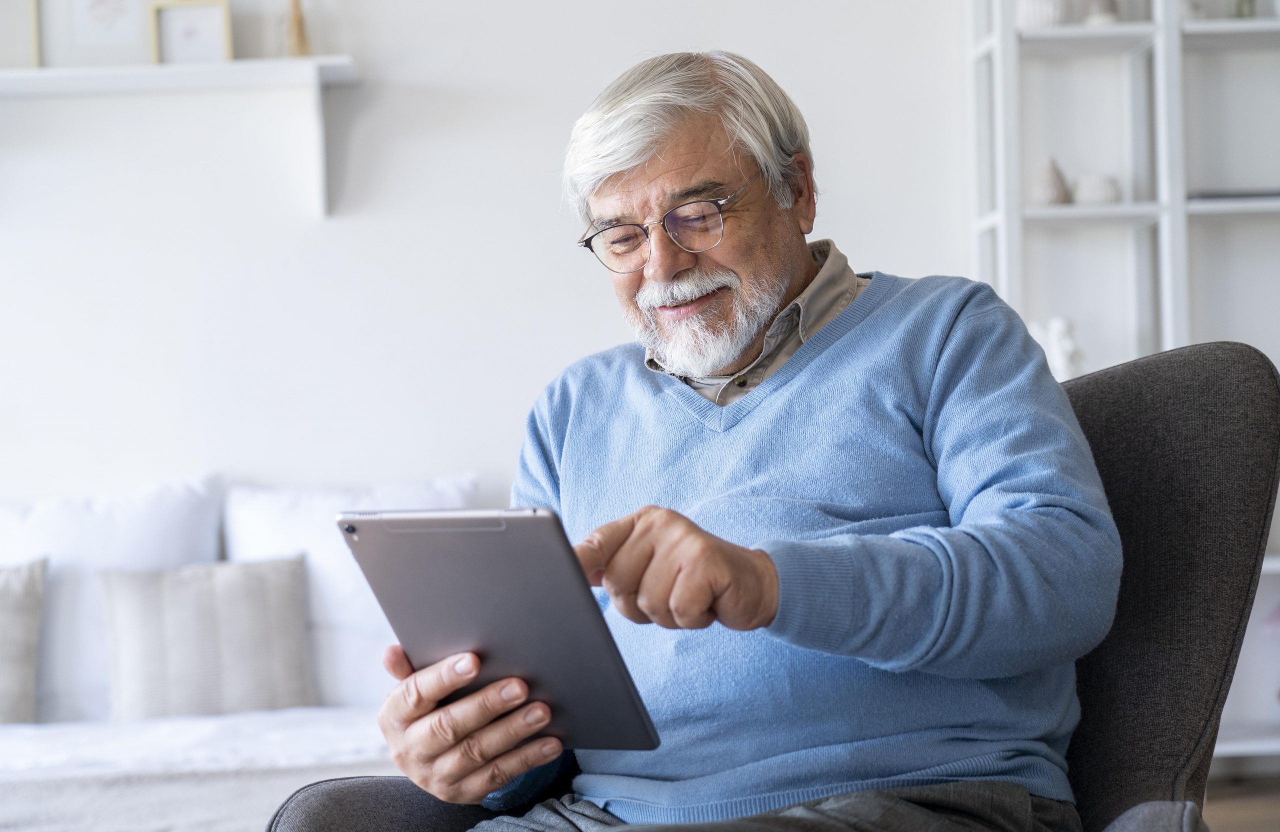 Senior man holding laptop illustrates blog "Does My Medicare Advantage Plan Renew Automatically?"