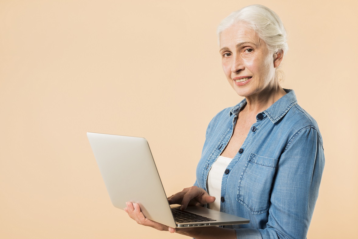 Senior lady holding laptop illustrates blog "Does Medicare Advantage Cover Root Canals?"