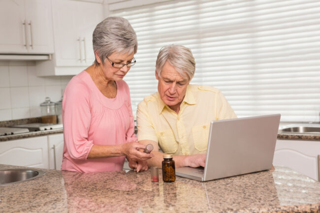 Senior couple conducting a Medicare Part D review with prescriptions and paperwork