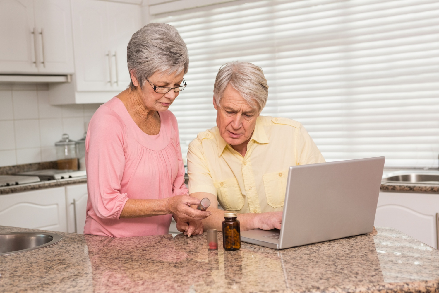 Senior couple conducting a Medicare Part D review with prescriptions and paperwork