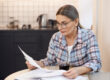 Older adult reading a Medicare Summary Notice and reviewing healthcare expenses