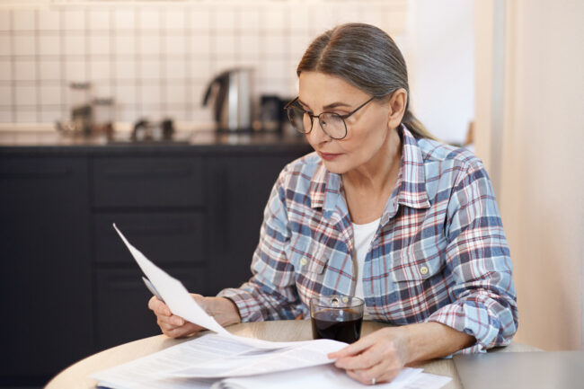 Older adult reading a Medicare Summary Notice and reviewing healthcare expenses Older adult reading a Medicare Summary Notice and reviewing healthcare expenses
